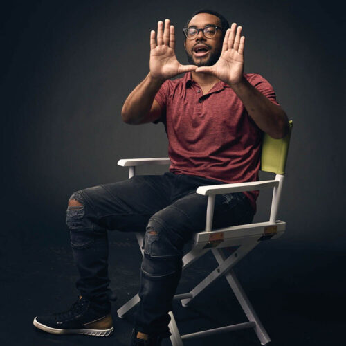 Full-body picture of Moses Conrad Norman sitting in a folding chair.